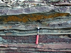 Pound Gap where the bedding character of the middle portion of the Mississippian Grainger Formation is composed of alternating relatively continuous to occasionally shallowly channeled thicker beds of sand with uniform sharp bedding planes and thin beds of shale; both lithologies vary in thickness and the sands often exhibit Bouma sequences suggesting deposition from turbidite currents that were active over a mid to outer fan setting